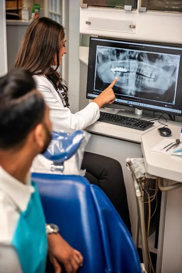 Photo of Dr. Pinky Vanmali showing a scan of X-Rays to a patient.