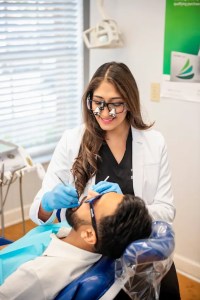 Photo of Dr. Pinky Vanmali performing an oral checkup on a patient.